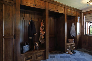 Photo of a mid-sized country mudroom in Minneapolis with slate floors, a dark wood front door and black floor.