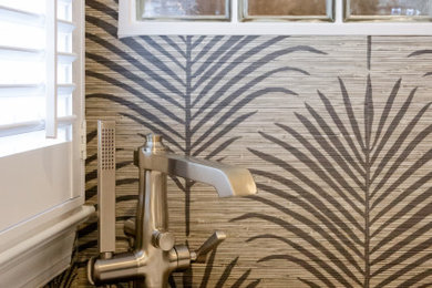 Bathroom - mid-sized transitional green tile and porcelain tile porcelain tile, white floor, double-sink and wallpaper bathroom idea in Charleston with recessed-panel cabinets, medium tone wood cabinets, a two-piece toilet, beige walls, a trough sink, quartz countertops, a hinged shower door, white countertops, a niche and a built-in vanity