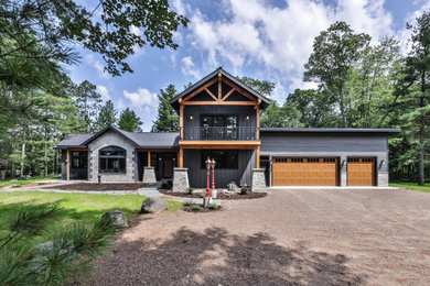 Inspiration for a large eclectic gray two-story board and batten exterior home remodel in Other with a mixed material roof and a gray roof