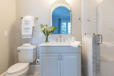 Mid-sized elegant 3/4 white tile and marble tile marble floor, white floor and single-sink shower bench photo in Richmond with raised-panel cabinets, white cabinets, a one-piece toilet, white walls, an undermount sink, marble countertops, a hinged shower door, white countertops and a built-in vanity