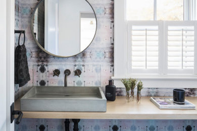 Powder room - mid-sized contemporary terra-cotta tile, gray floor and wallpaper powder room idea in New York with wood countertops and a floating vanity