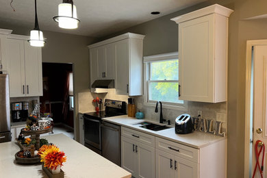 Example of a mid-sized minimalist eat-in kitchen design in Indianapolis with shaker cabinets, quartz countertops and an island