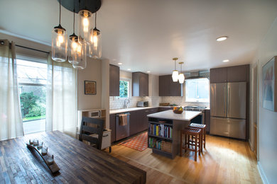 This is an example of a small contemporary l-shaped eat-in kitchen in Seattle with an undermount sink, quartz benchtops, white splashback, subway tile splashback, stainless steel appliances, light hardwood floors and with island.