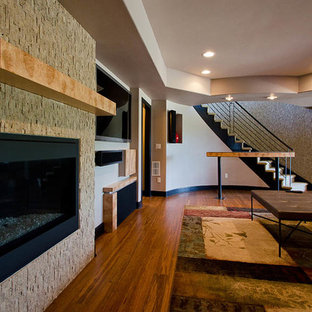 Ejemplo de sótano con puerta actual, extra grande, con suelo de bambú, chimenea tradicional y marco de chimenea de piedra