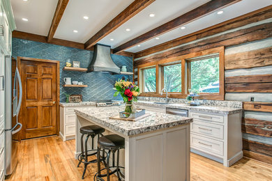 This is an example of a country l-shaped kitchen in Nashville with white cabinets, quartz benchtops, blue splashback, light hardwood floors, with island, multi-coloured benchtop, an undermount sink, shaker cabinets, stainless steel appliances and beige floor.