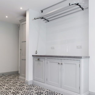 Inspiration for an expansive contemporary u-shaped utility room in Kent with shaker cabinets, grey cabinets, ceramic flooring, a side by side washer and dryer, laminate countertops, grey walls, yellow floors and grey worktops.