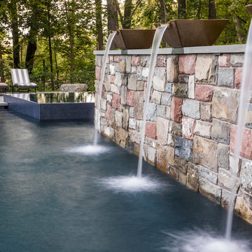 Clean line infinity edge with peremiter overflow spa and detailed stonework