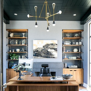 Inredning av ett 50 tals hemmabibliotek, med grå väggar och ett fristående skrivbord