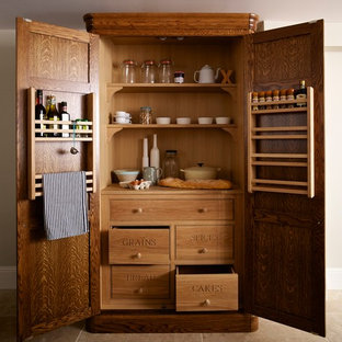 Mid-sized farmhouse kitchen pantry remodeling - Example of a mid-sized farmhouse l-shaped travertine floor kitchen pantry design in Essex with an undermount sink, flat-panel cabinets, medium tone wood cabinets, wood countertops, multicolored backsplash, ceramic backsplash, black appliances and an island