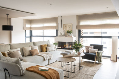 Diseño de salón abierto y blanco y madera contemporáneo grande con suelo de madera en tonos medios, chimenea lineal, marco de chimenea de metal, televisor colgado en la pared, suelo marrón y alfombra