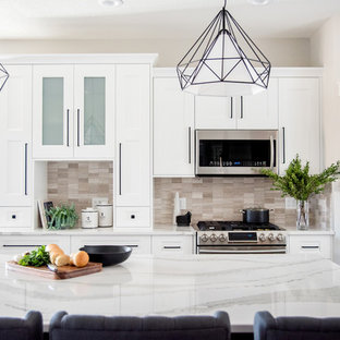 Inspiration för mellanstora klassiska kök, med en undermonterad diskho, skåp i shakerstil, vita skåp, bänkskiva i kvartsit, beige stänkskydd, stänkskydd i kalk, rostfria vitvaror, klinkergolv i keramik, en köksö och grått golv