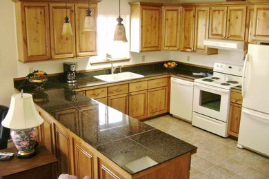 Example of a classic u-shaped eat-in kitchen design in Seattle with raised-panel cabinets, light wood cabinets, granite countertops and white appliances