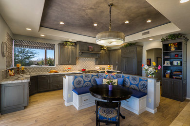 Large elegant u-shaped porcelain tile open concept kitchen photo in Phoenix with a farmhouse sink, raised-panel cabinets, gray cabinets, quartz countertops, gray backsplash, ceramic backsplash, paneled appliances and an island