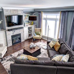 Modern inredning av ett allrum med öppen planlösning, med blå väggar, en spiselkrans i trä och en väggmonterad TV