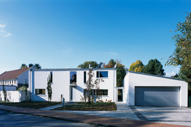 Großes, Zweistöckiges Modernes Einfamilienhaus mit Putzfassade, weißer Fassadenfarbe und Flachdach in Düsseldorf