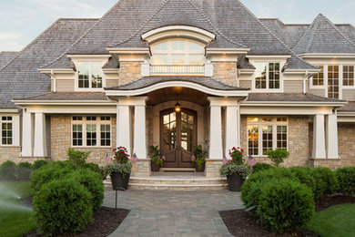 This is an example of a large beach style two-storey beige exterior in Minneapolis with mixed siding and a hip roof.