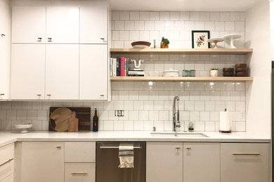 Design ideas for a mid-sized modern l-shaped separate kitchen in Los Angeles with a single-bowl sink, flat-panel cabinets, white cabinets, quartz benchtops, white splashback, subway tile splashback, stainless steel appliances, a peninsula, dark hardwood floors and brown floor.