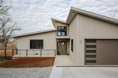 Example of a mid-sized minimalist concrete floor and gray floor entryway design in Other with beige walls and a gray front door