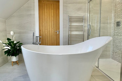 Design ideas for a large modern grey and white ensuite bathroom in Other with grey cabinets, a freestanding bath, a walk-in shower, a one-piece toilet, grey tiles, ceramic tiles, white walls, grey floors, a sliding door, a feature wall, a single sink and a floating vanity unit.