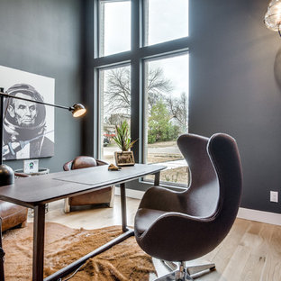 Modern study in Dallas with black walls, light hardwood flooring and a freestanding desk.