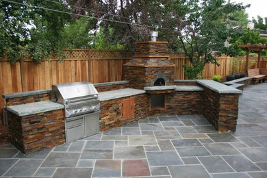 Example of a large classic backyard concrete paver patio kitchen design in San Francisco with no cover
