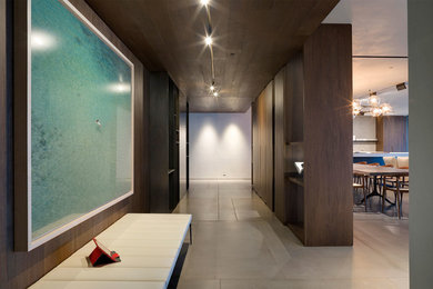 Foyer - mid-sized contemporary porcelain tile and beige floor foyer idea in Miami with brown walls and a dark wood front door