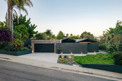 Small black one-story brick exterior home photo in Orange County with a mixed material roof and a gray roof