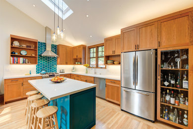 Mid-sized trendy l-shaped light wood floor and vaulted ceiling open concept kitchen photo in San Francisco with a drop-in sink, shaker cabinets, medium tone wood cabinets, granite countertops, white backsplash, subway tile backsplash, stainless steel appliances, an island and white countertops