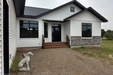 Inspiration for a farmhouse white one-story vinyl house exterior remodel in Other with a gray roof