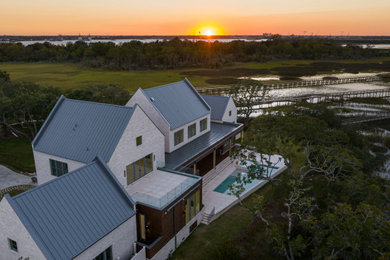 Großes, Zweistöckiges Modernes Einfamilienhaus mit Backsteinfassade, beiger Fassadenfarbe, Satteldach, Blechdach und grauem Dach in Charleston