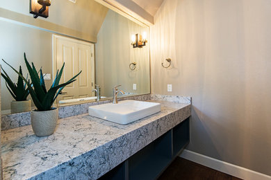 Powder room - mid-sized transitional medium tone wood floor and brown floor powder room idea in Other with a drop-in sink and gray cabinets