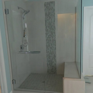 Enlarged shower with glass accent tile in a waterfall evokes a spa feeling.