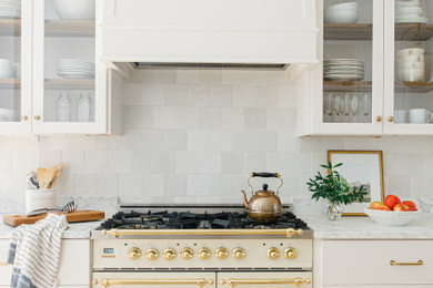 Imagen de cocina clásica de tamaño medio con armarios tipo vitrina, encimera de mármol, salpicadero blanco y salpicadero de azulejos de cerámica