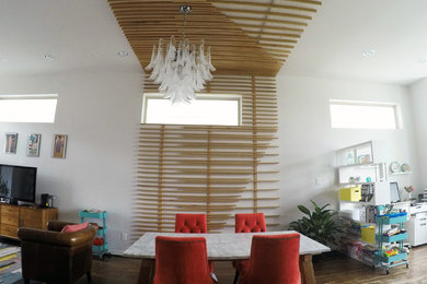 Example of a large minimalist dark wood floor and brown floor great room design in Houston with white walls and no fireplace