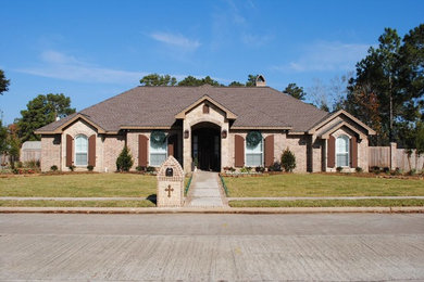 Inspiration for a large timeless red two-story brick exterior home remodel in Houston with a shingle roof