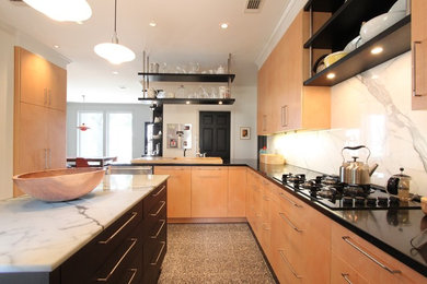 Enclosed kitchen - mid-sized contemporary u-shaped ceramic tile and beige floor enclosed kitchen idea in Houston with flat-panel cabinets, light wood cabinets, marble countertops, gray backsplash, stone slab backsplash, stainless steel appliances and a peninsula