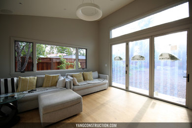 Example of a large trendy open concept light wood floor, beige floor and vaulted ceiling living room design in San Francisco with beige walls