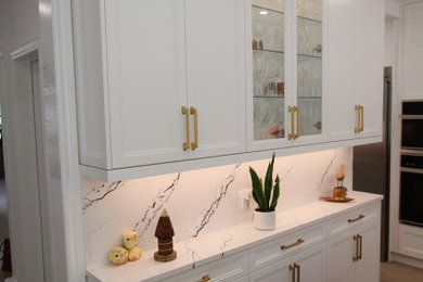 Example of a huge trendy u-shaped light wood floor and beige floor eat-in kitchen design in Toronto with an undermount sink, recessed-panel cabinets, white cabinets, quartz countertops, white backsplash, quartz backsplash, stainless steel appliances, an island and white countertops