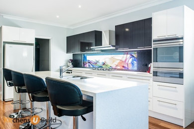This is an example of a mid-sized modern galley eat-in kitchen in Melbourne with a drop-in sink, open cabinets, white cabinets, quartz benchtops, multi-coloured splashback, glass sheet splashback, stainless steel appliances, light hardwood floors and with island.