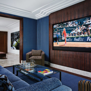 Idée de décoration pour une salle de cinéma design fermée avec un mur bleu, moquette, un téléviseur fixé au mur et un sol bleu.