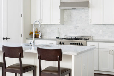 Example of a transitional open concept kitchen design in Houston with a double-bowl sink, recessed-panel cabinets, white cabinets, marble countertops, gray backsplash, mosaic tile backsplash, stainless steel appliances and an island