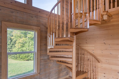 Mountain style wooden spiral staircase photo in Philadelphia with wooden risers