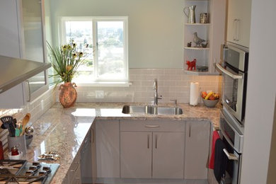 Inspiration for a small modern u-shaped medium tone wood floor kitchen remodel in San Francisco with an undermount sink, flat-panel cabinets, gray cabinets, granite countertops, brown backsplash, ceramic backsplash, stainless steel appliances and no island