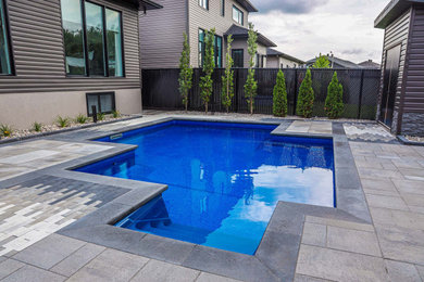 Mid-sized trendy backyard stone and custom-shaped pool landscaping photo in Ottawa