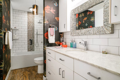 Bathroom - contemporary white tile and ceramic tile dark wood floor and brown floor bathroom idea in Miami with flat-panel cabinets, white cabinets, multicolored walls, an undermount sink and white countertops