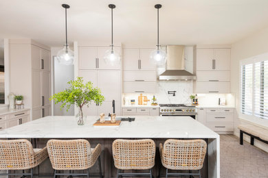 Transitional l-shaped gray floor kitchen photo in Phoenix with an undermount sink, shaker cabinets, beige cabinets, white backsplash, stone slab backsplash, stainless steel appliances, an island and white countertops