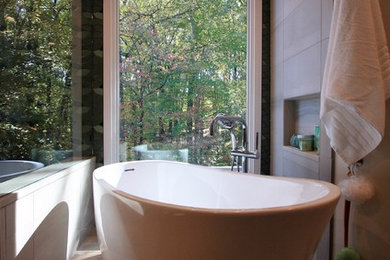 Inspiration for a mid-sized asian master bathroom in DC Metro with flat-panel cabinets, light wood cabinets, a japanese tub, a corner shower, a one-piece toilet, green tile, porcelain tile, green walls, porcelain floors, a vessel sink, engineered quartz benchtops, brown floor and a hinged shower door.