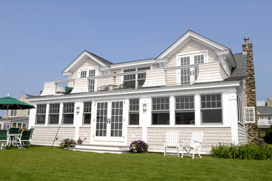 Mid-sized beach style two-storey grey house exterior in Other with wood siding, a gable roof and a shingle roof.