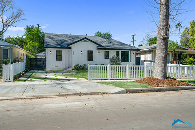 Inspiration for a mid-sized contemporary white one-story exterior home remodel in Los Angeles with a shingle roof