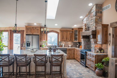 Large farmhouse l-shaped brick floor, multicolored floor and vaulted ceiling eat-in kitchen photo in Chicago with a farmhouse sink, raised-panel cabinets, dark wood cabinets, granite countertops, beige backsplash, ceramic backsplash, black appliances, an island and multicolored countertops